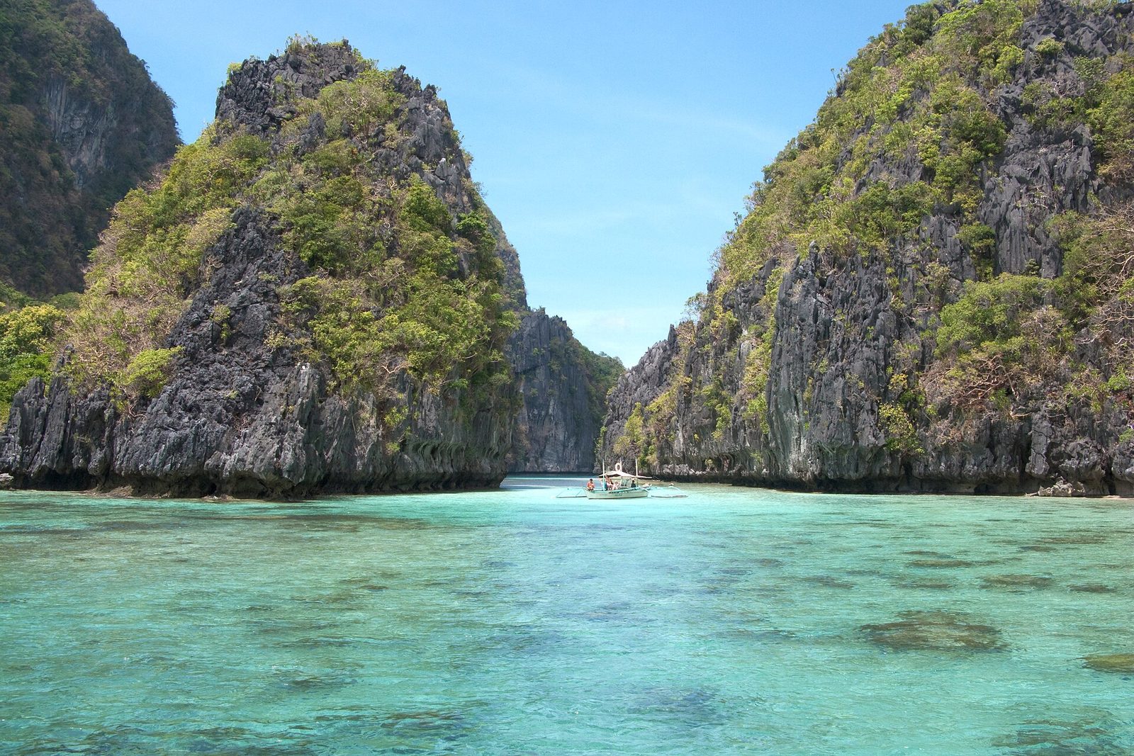 A turquoise lagoon between limestone cliffs in Bacuit Bay, El Nido