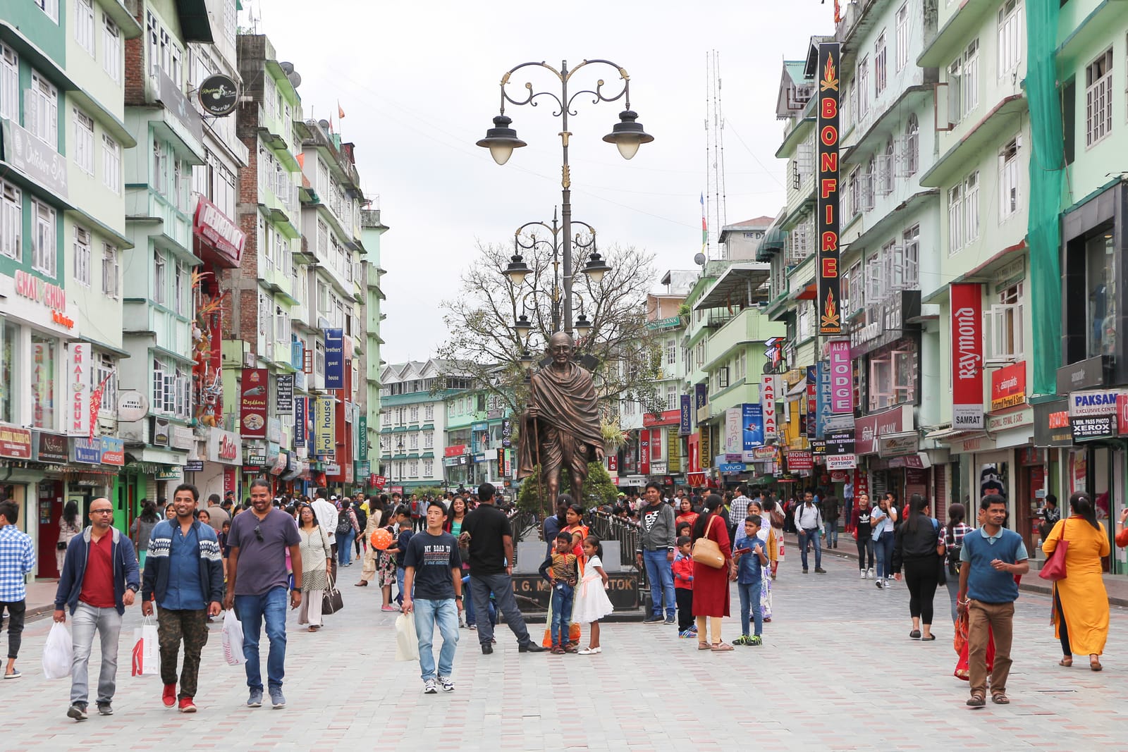 Shoppers walking the pedestrianised MG Marg in Gangtok between rows of painted shopfronts
